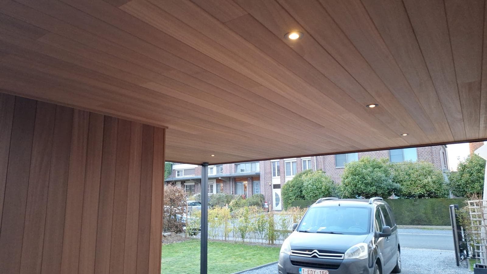 Houten carportplafond met ingebouwde spots en zicht op de straat