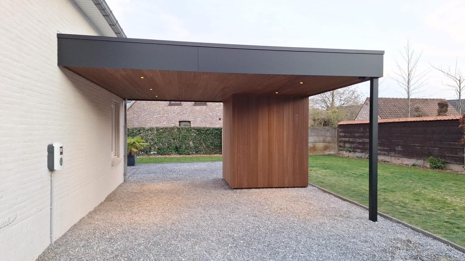 Moderne carport met platdak en geïntegreerde houten tuinberging in Ayous thermo, WoPa Construction