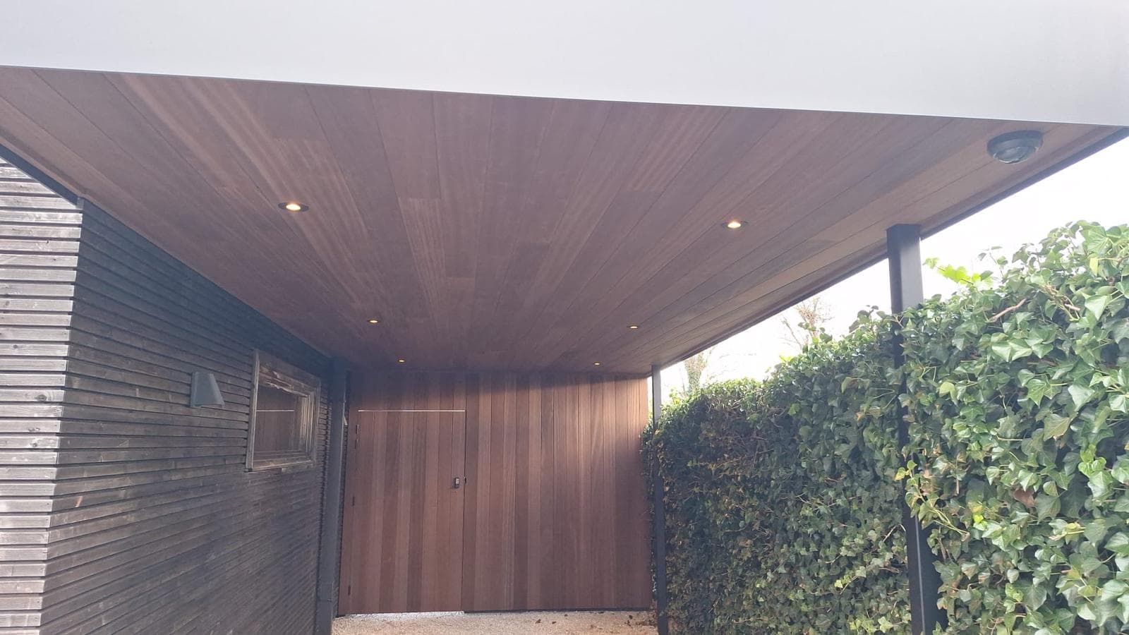 Ondersicht van het houten plafond met ingebouwde spots onder de carport