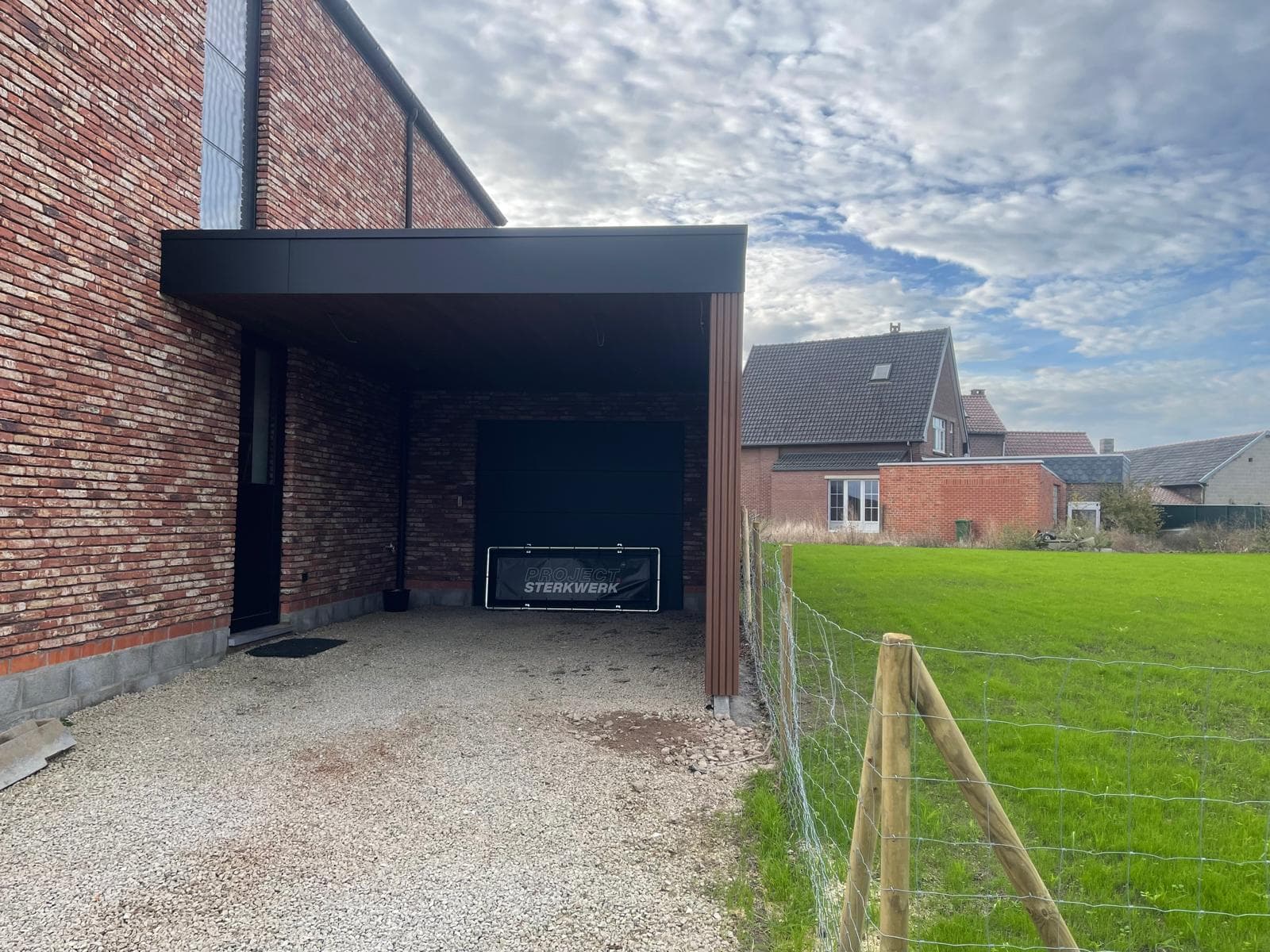Carport aangebouwd aan de woning met zicht op het aangrenzende weiland