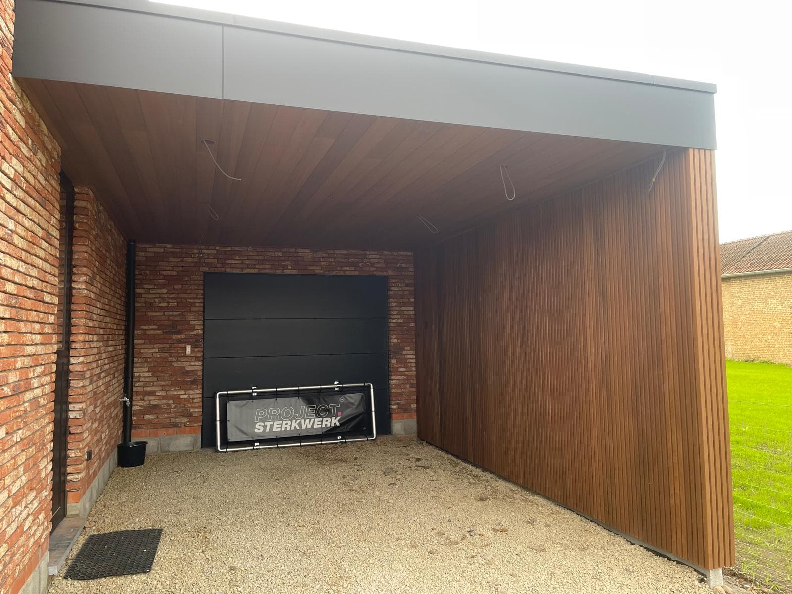 Interieur van de carport met Ayous thermo wand en plafond en zwarte sectionaalpoort