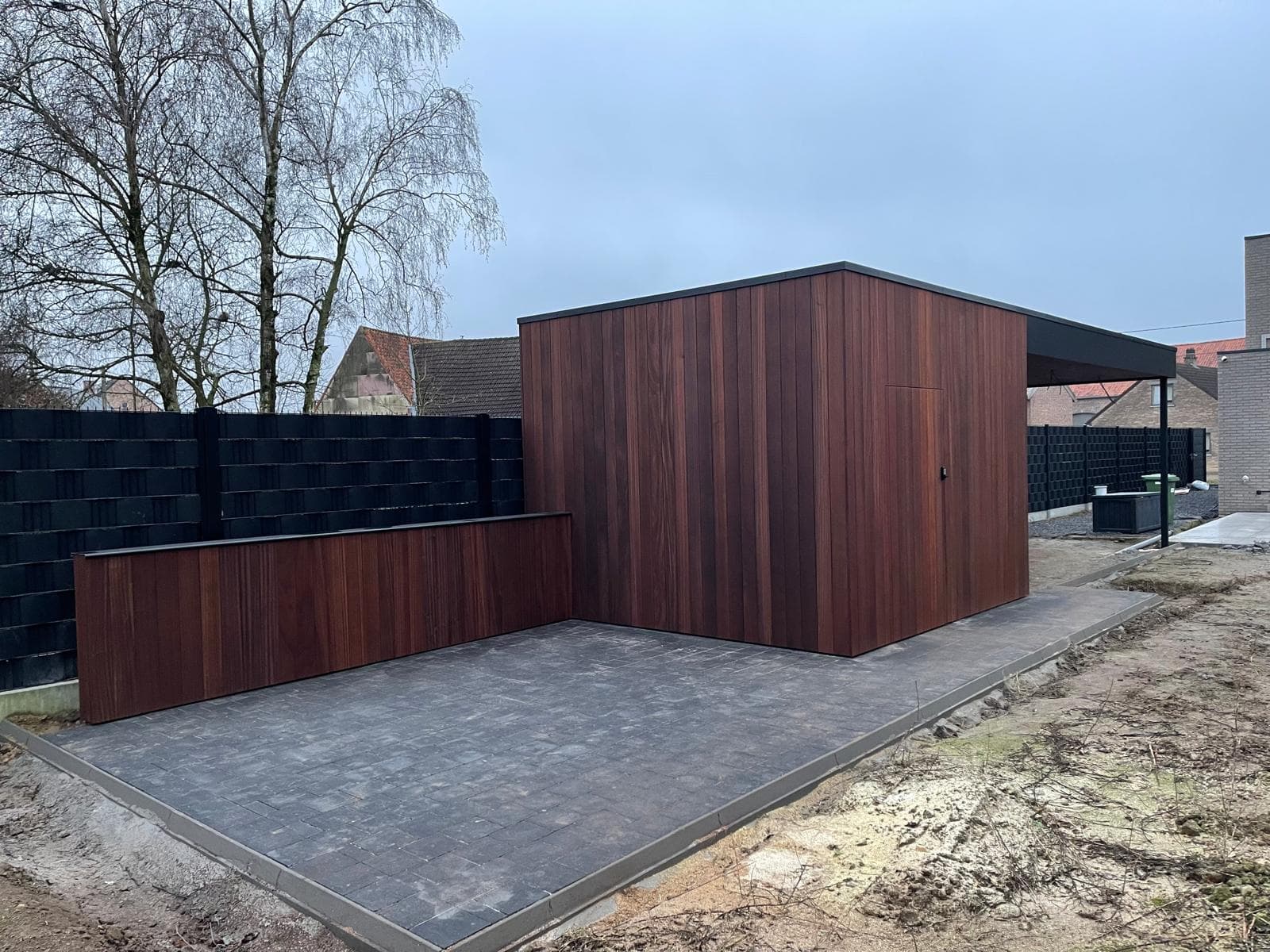 Tuinberging in Ayous thermohout met zwarte trespa op een betegeld terras