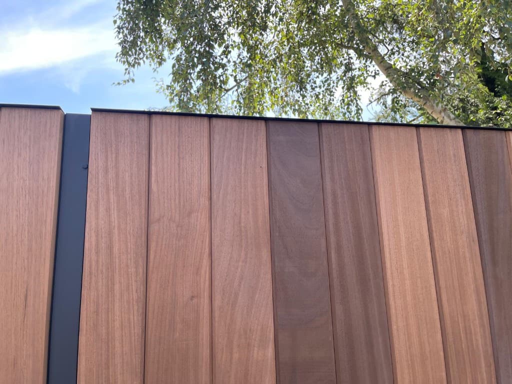 Detail van verticale Ayous-planken met zwarte metalen daktrim