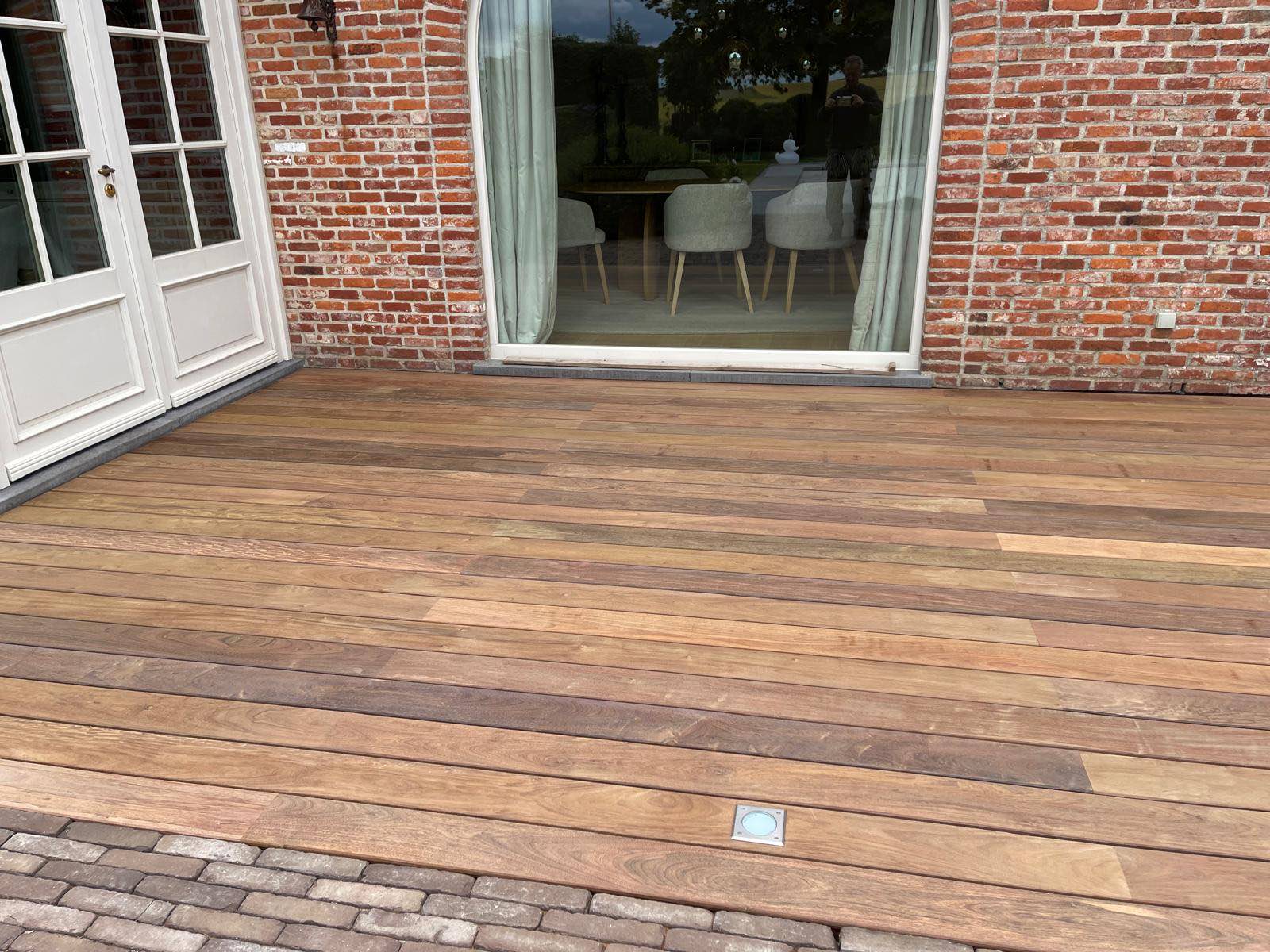 Detail van de strak gelegde IPE-planken met ingebouwde grondspot voor de schuifpui