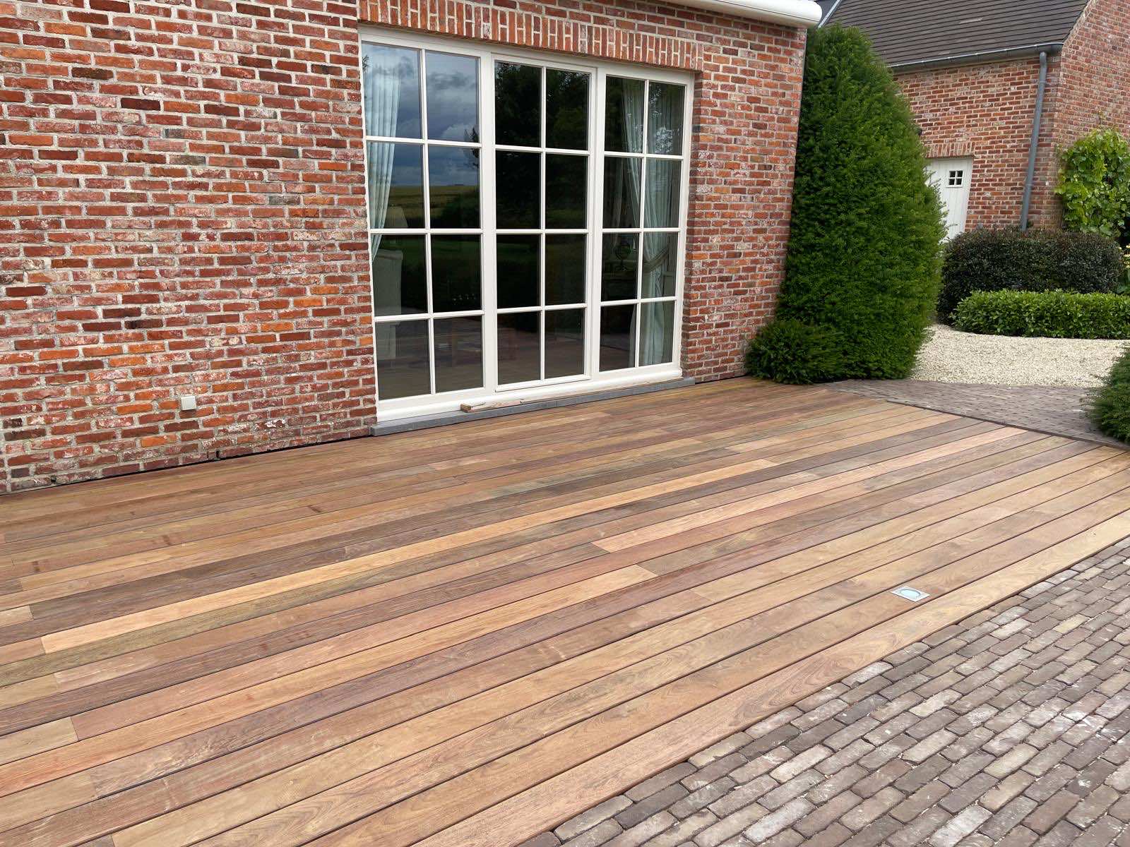 Hoek van het IPE-terras waar de hardhouten planken overgaan in de klinkerbestrating