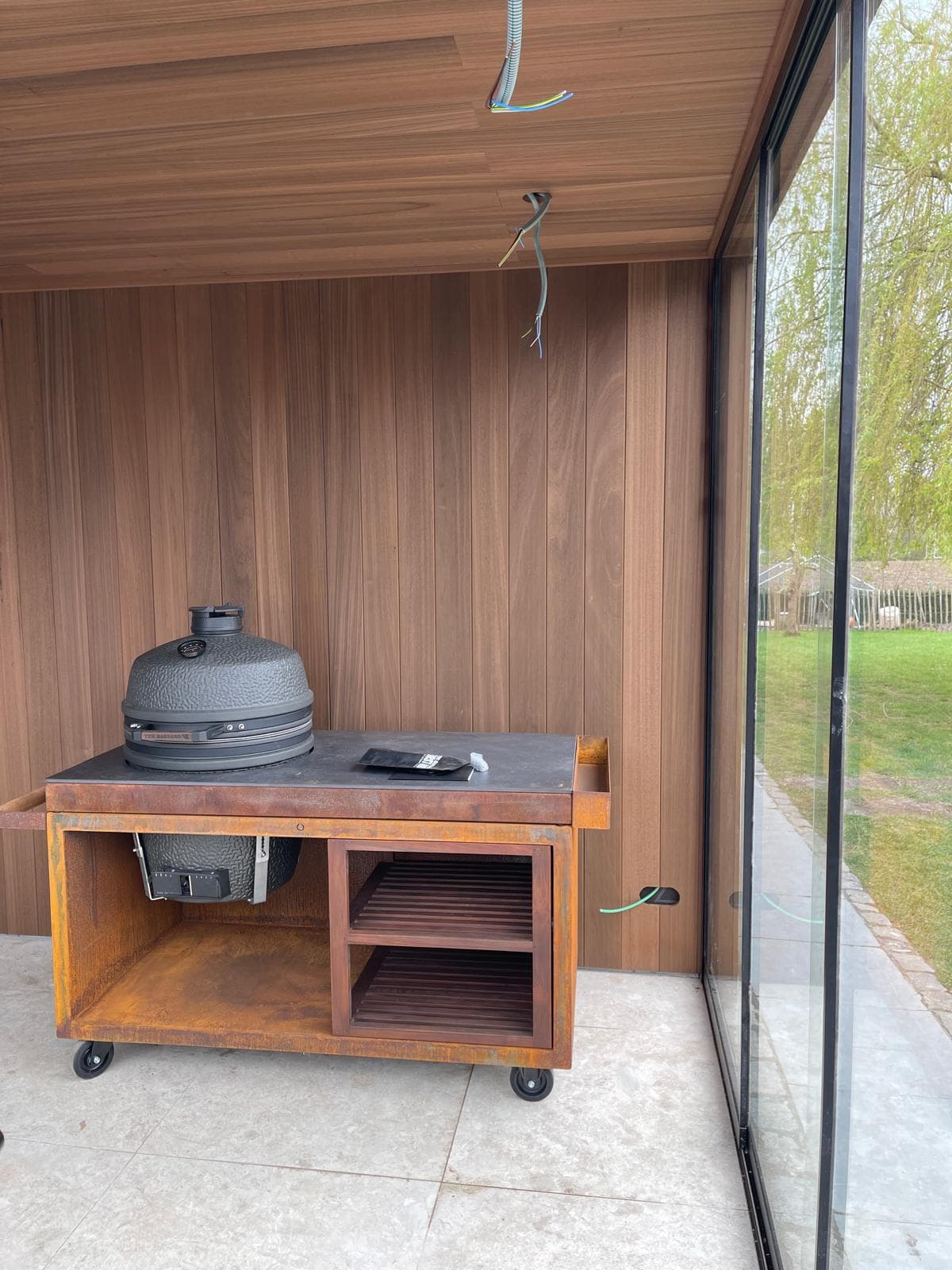 Interieur met Ayous thermo plafond en wandbekleding naast de glazen schuifwand