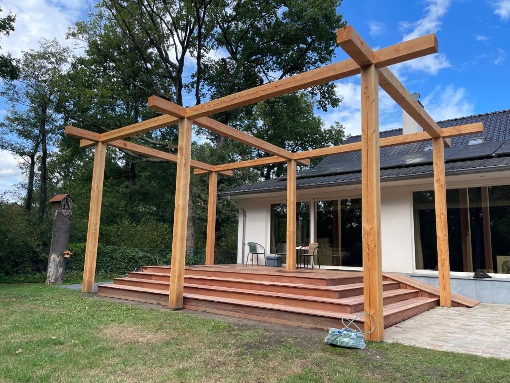 Open douglas-pergola boven een Cumaru terras met brede trap en hellingbaan, WoPa Construction