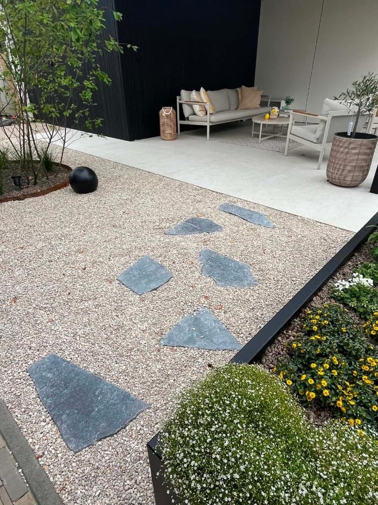 Overzicht van poolhouse met lounge, witte Trespa, zwarte Ayous en aangelegd kiezeltuintje