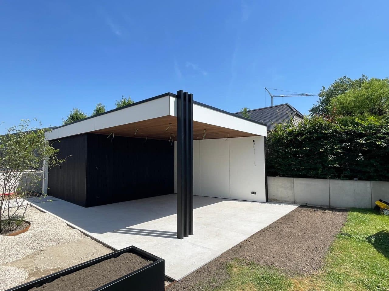 Overdekte loungeplek onder een warm Ayous plafond met zwarte aluminium kolommen