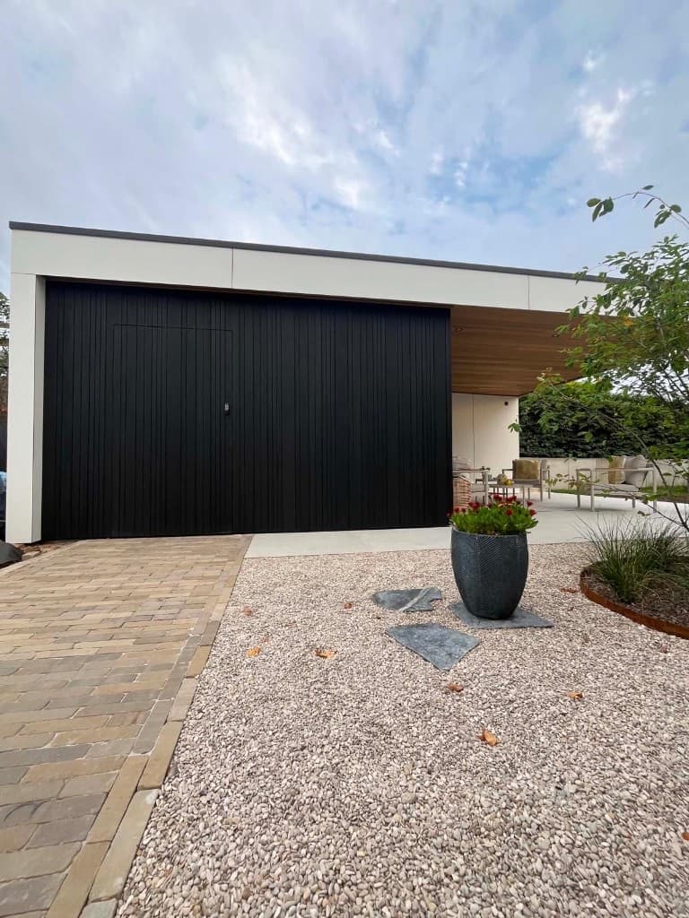 Poolhouse vanaf het klinkerpad: zwarte Ayous, witte Trespa en lounge achteraan