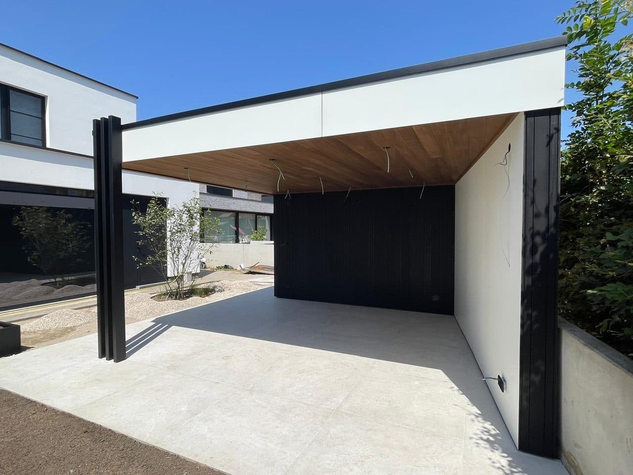 Overkapping van de poolhouse afgestemd op de witte moderne woning op de achtergrond