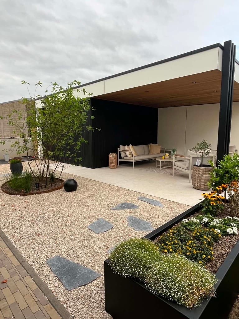 Poolhouse met open lounge, witte Trespa, zwarte Ayous vario en trio zwarte palen naast kiezeltuintje, WoPa Construction