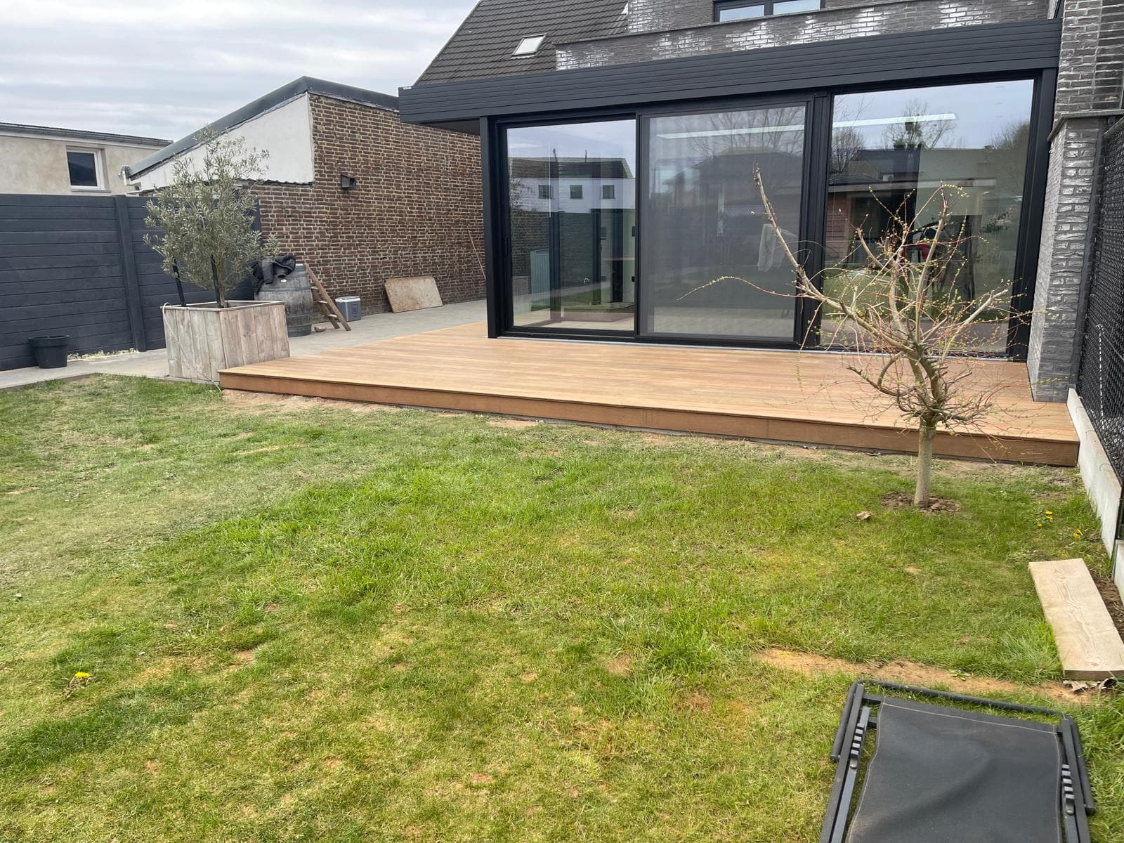 Tali terras grenzend aan een verzorgd gazon achter een moderne woning