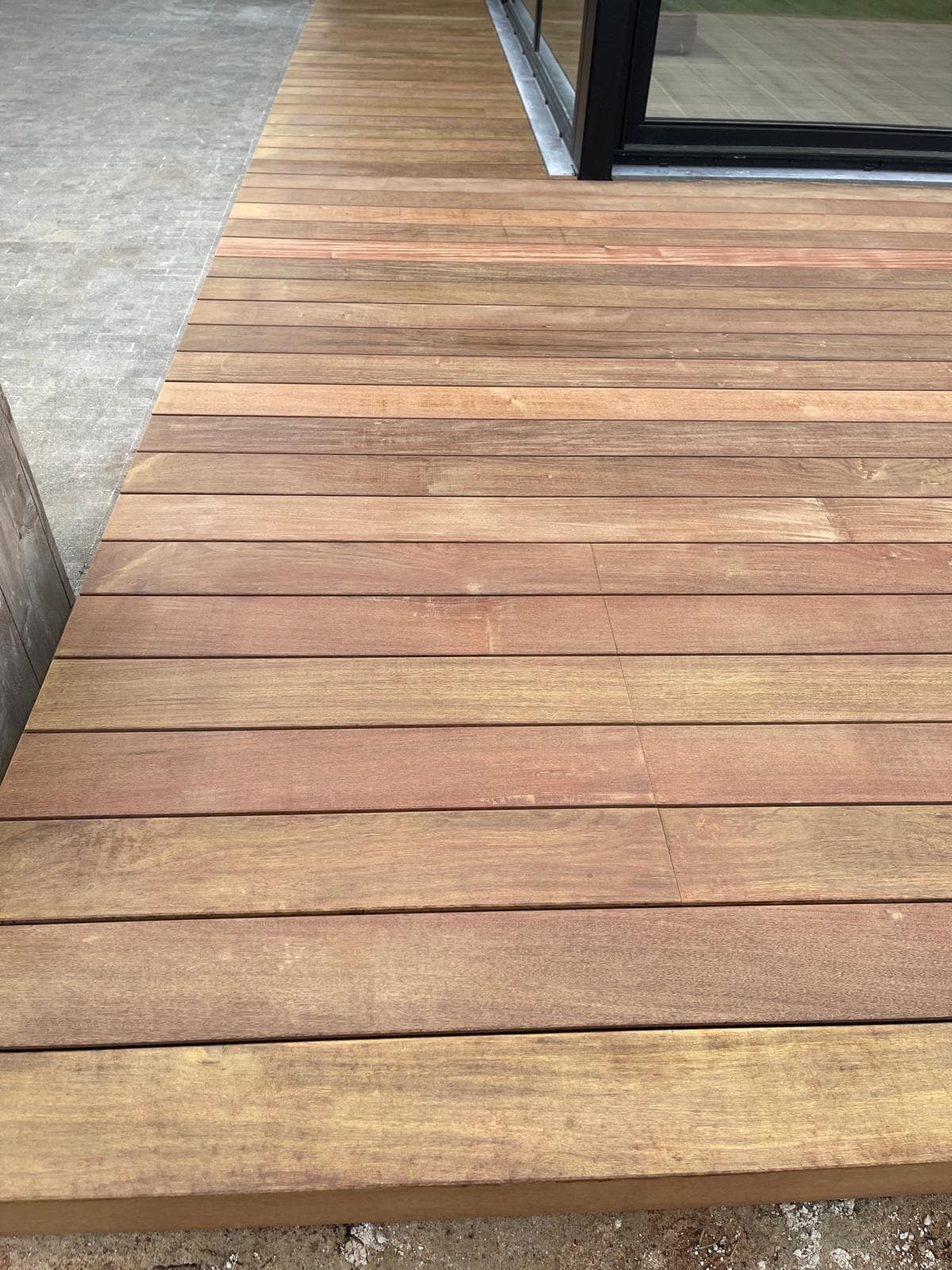 Nette hoekafwerking van het Tali terras langs de zijgevel met plantenpot