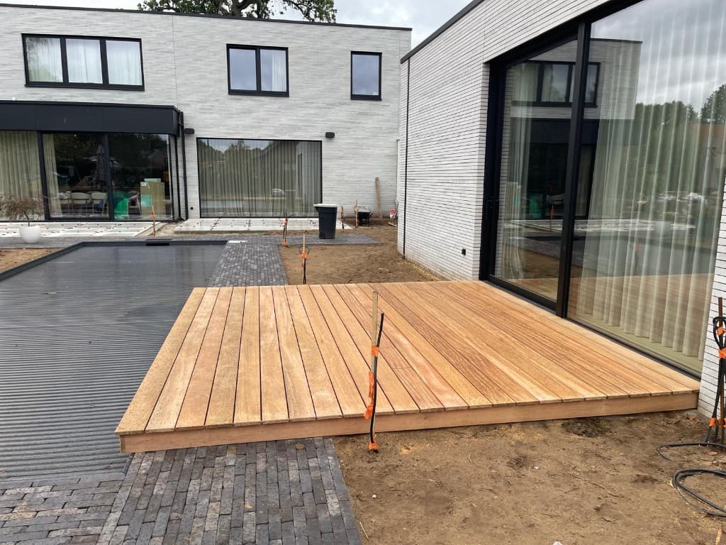 Breed overzicht van het Tali terras in de tuin bij pool en woning