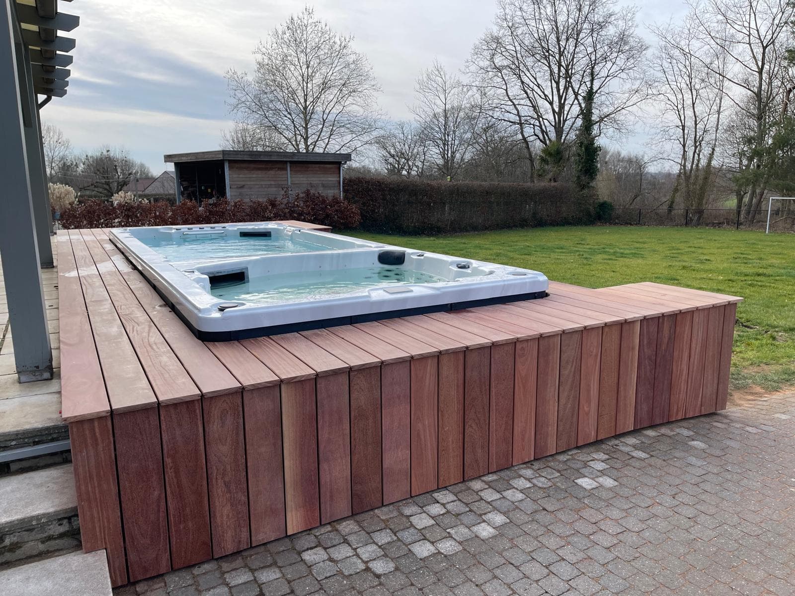 Cumaru terras met verlaagde swim-spa en zitrand richting de tuin