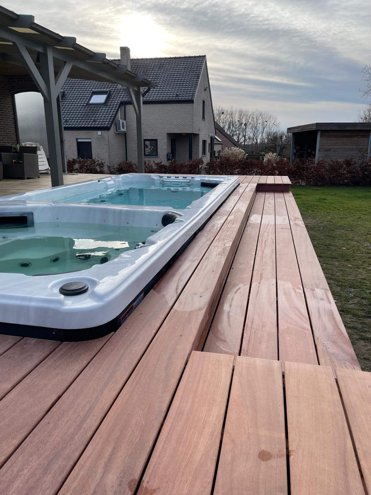 Detail van de warme Cumaru planken naast de swim-spa bij avondlicht