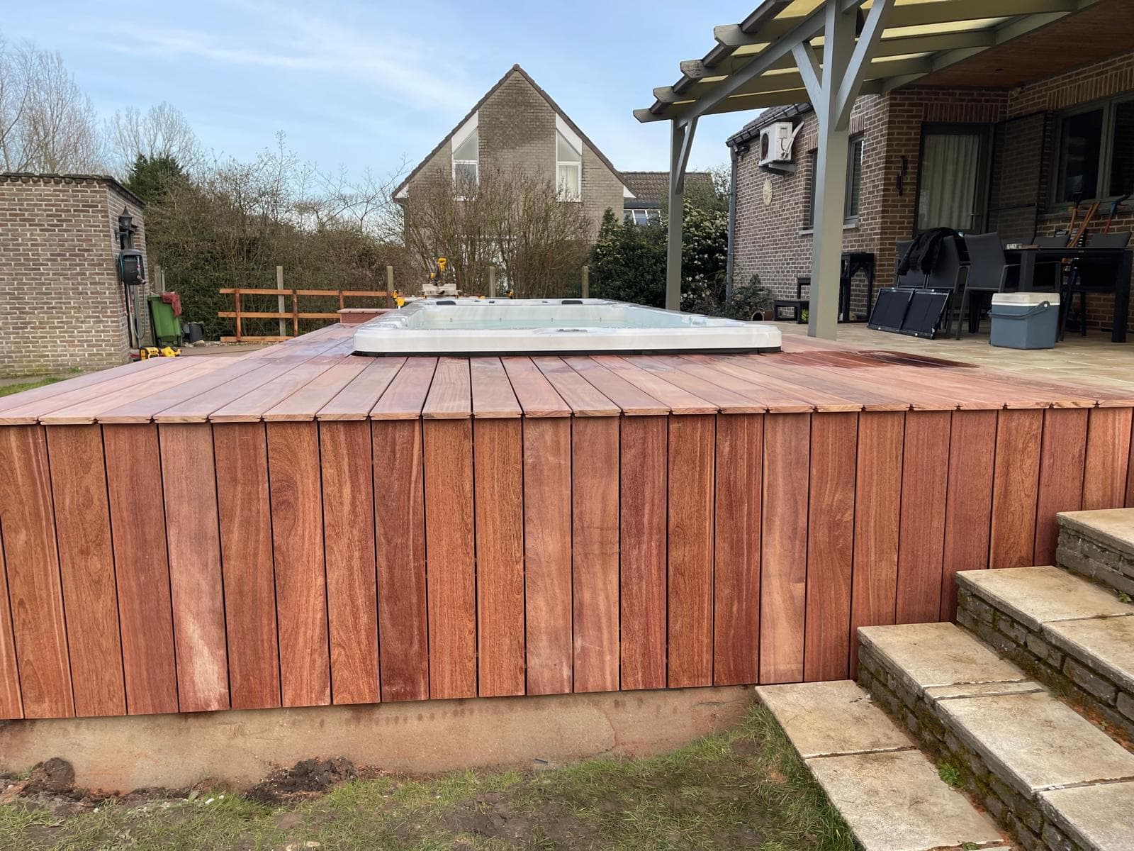 Verticale Cumaru bekleding van de terrasopstand met natuurstenen trap