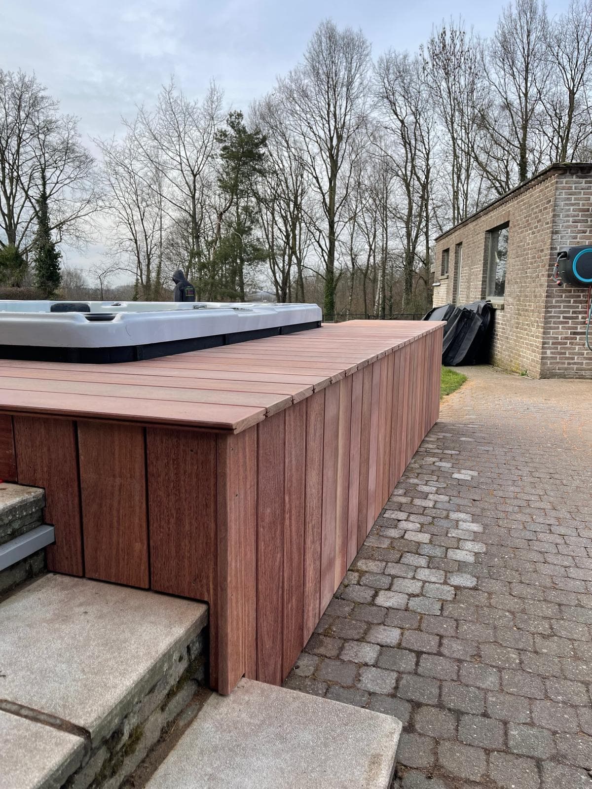 Langwerpig Cumaru terras met swim-spa en hardhouten zijbekleding op klinkers