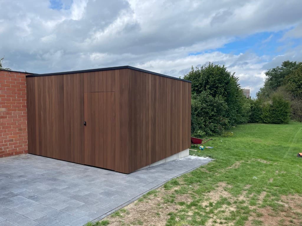Gesloten Ayous-gevel met verborgen deur en codeslot tegen de bakstenen garage