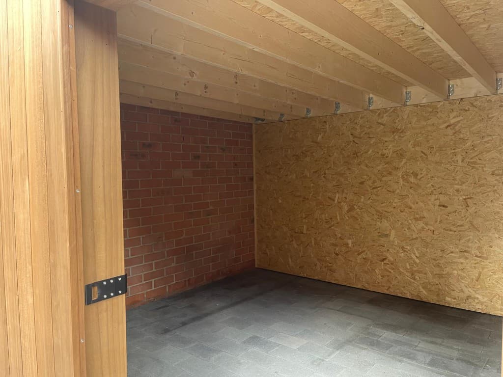 Interieur met OSB-wand, bakstenen garagewand en dakbalken