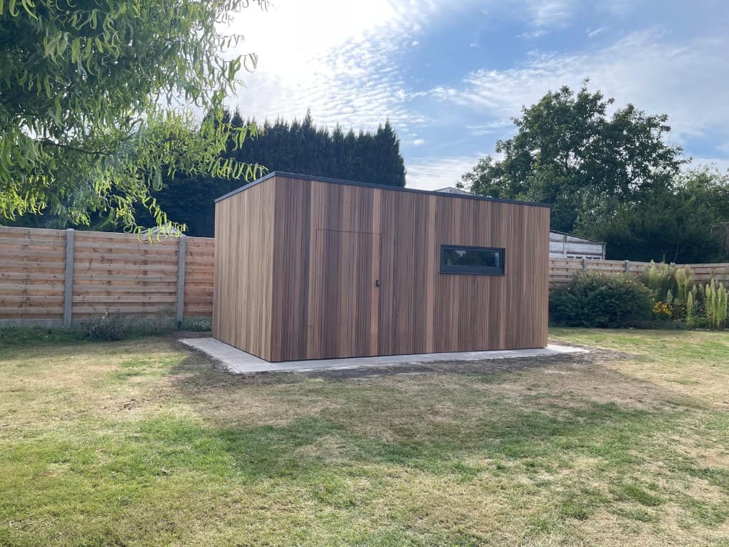 Vrijstaande tuinberging in verticale Ayous thermo klikplanken met plat dak en zwart raam, WoPa Construction