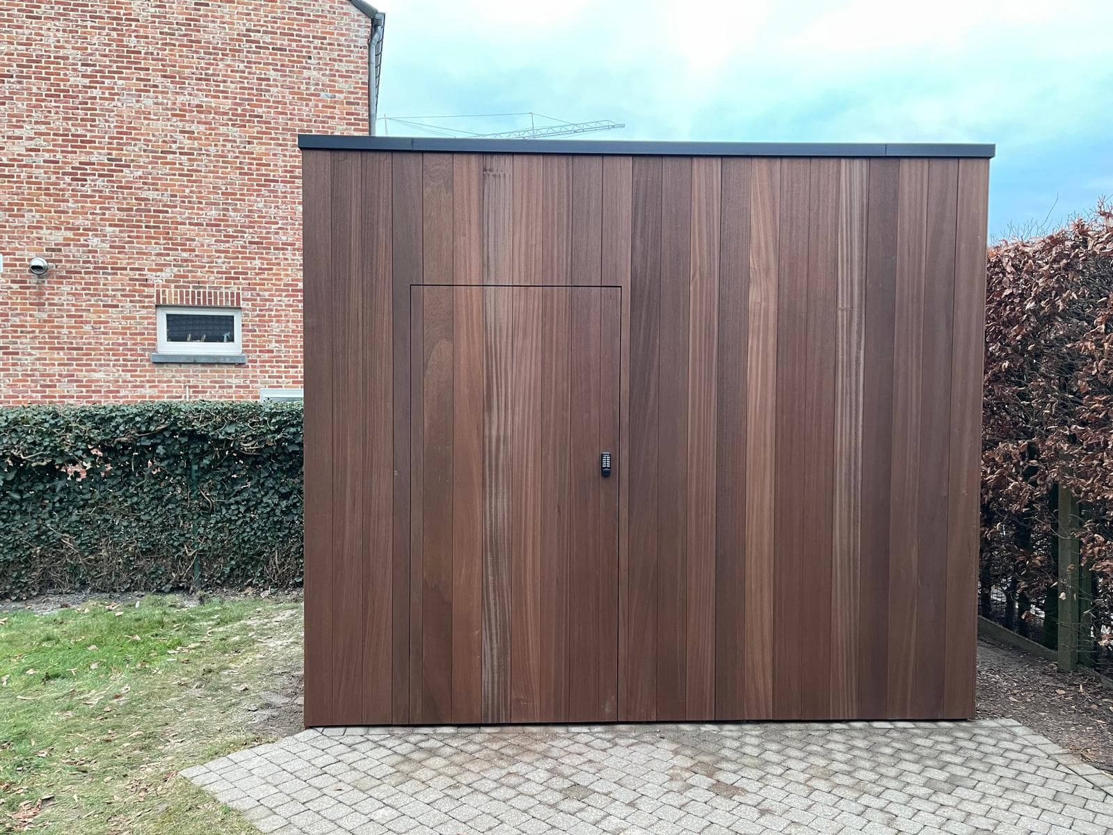 Tuinhuisje recht van voren met strakke houten gevel en antraciet dakrand